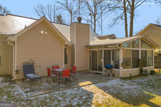 a view of a house with backyard and chairs