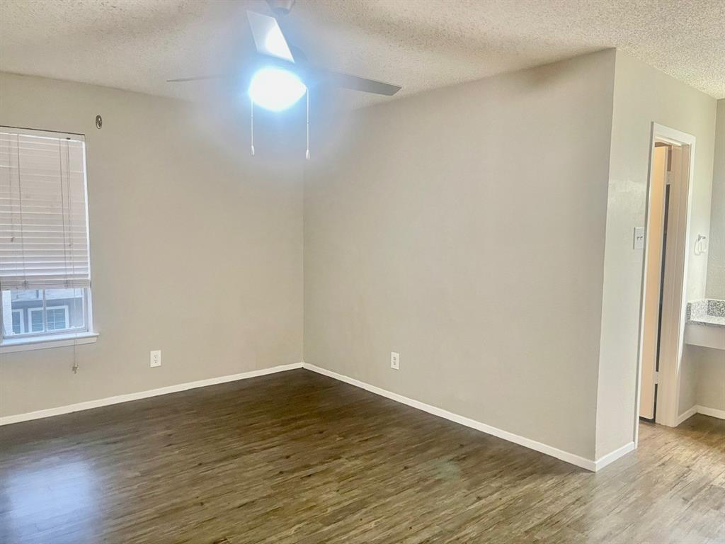 5300 Keller Springs Road, Unit 2080 Dallas, TX 75248 - Photo 12 of 28 an empty room with wooden floor and windows