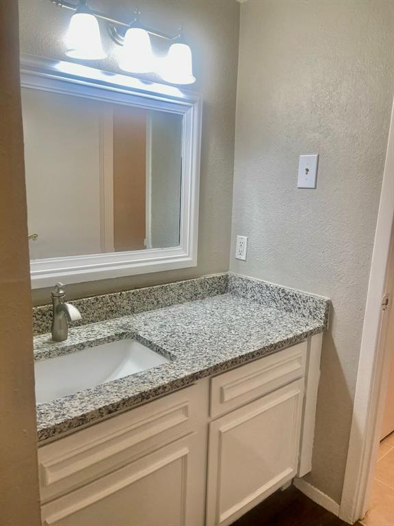 5300 Keller Springs Road, Unit 2080 Dallas, TX 75248 - Photo 20 of 28 a bathroom with a granite countertop sink and a mirror