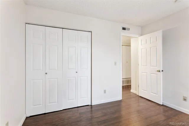 an empty room with wooden floor and window