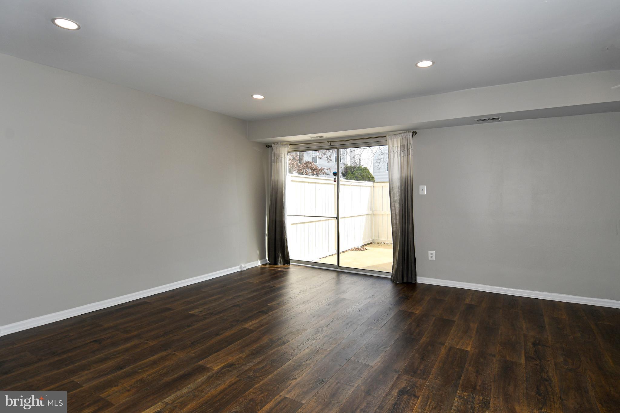 53 Essex Square Sterling, VA 20164 - Photo 5 of 25 a view of an empty room with wooden floor and a window