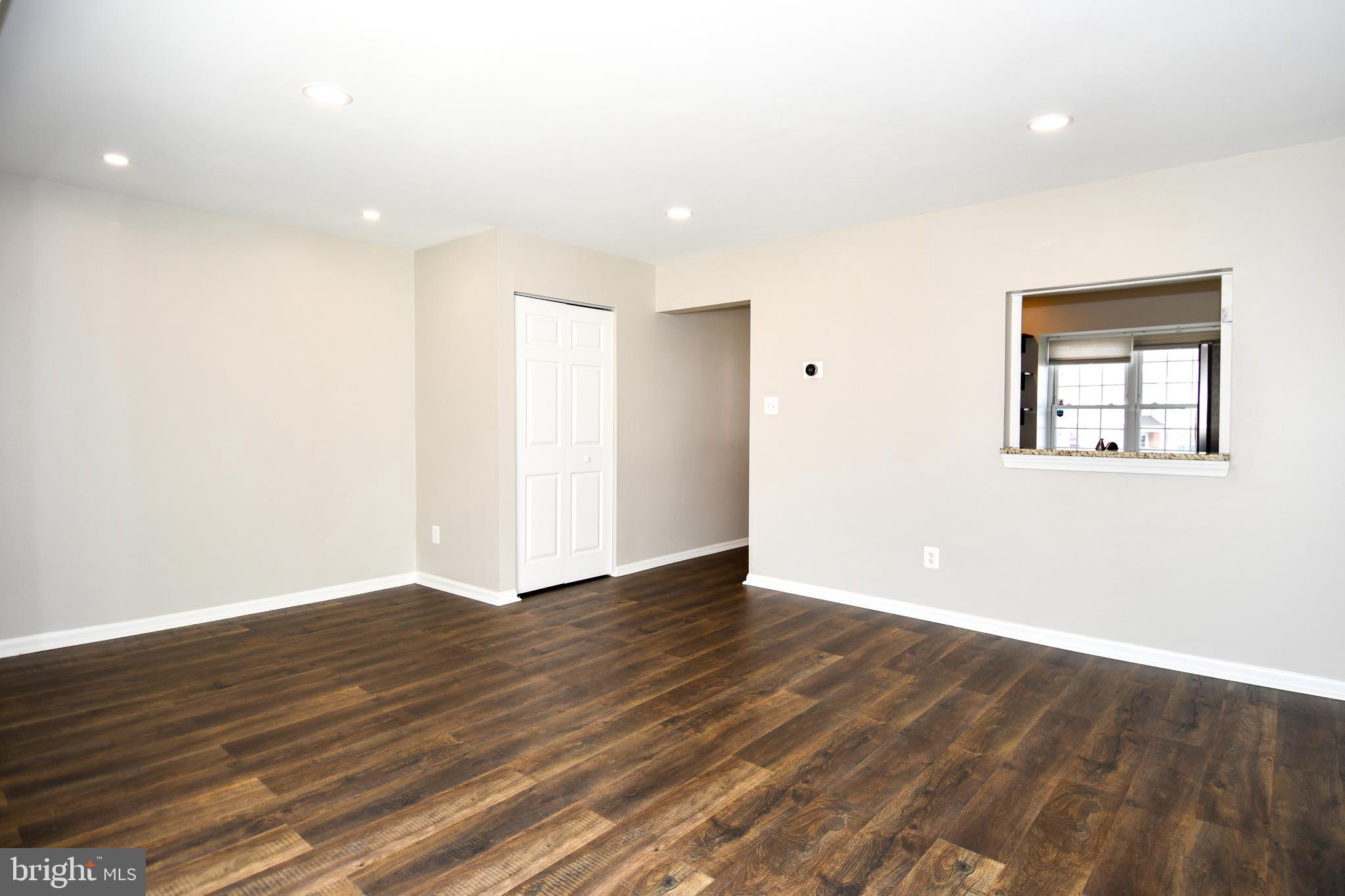 53 Essex Square Sterling, VA 20164 - Photo 7 of 25 a view of an empty room with wooden floor and a window