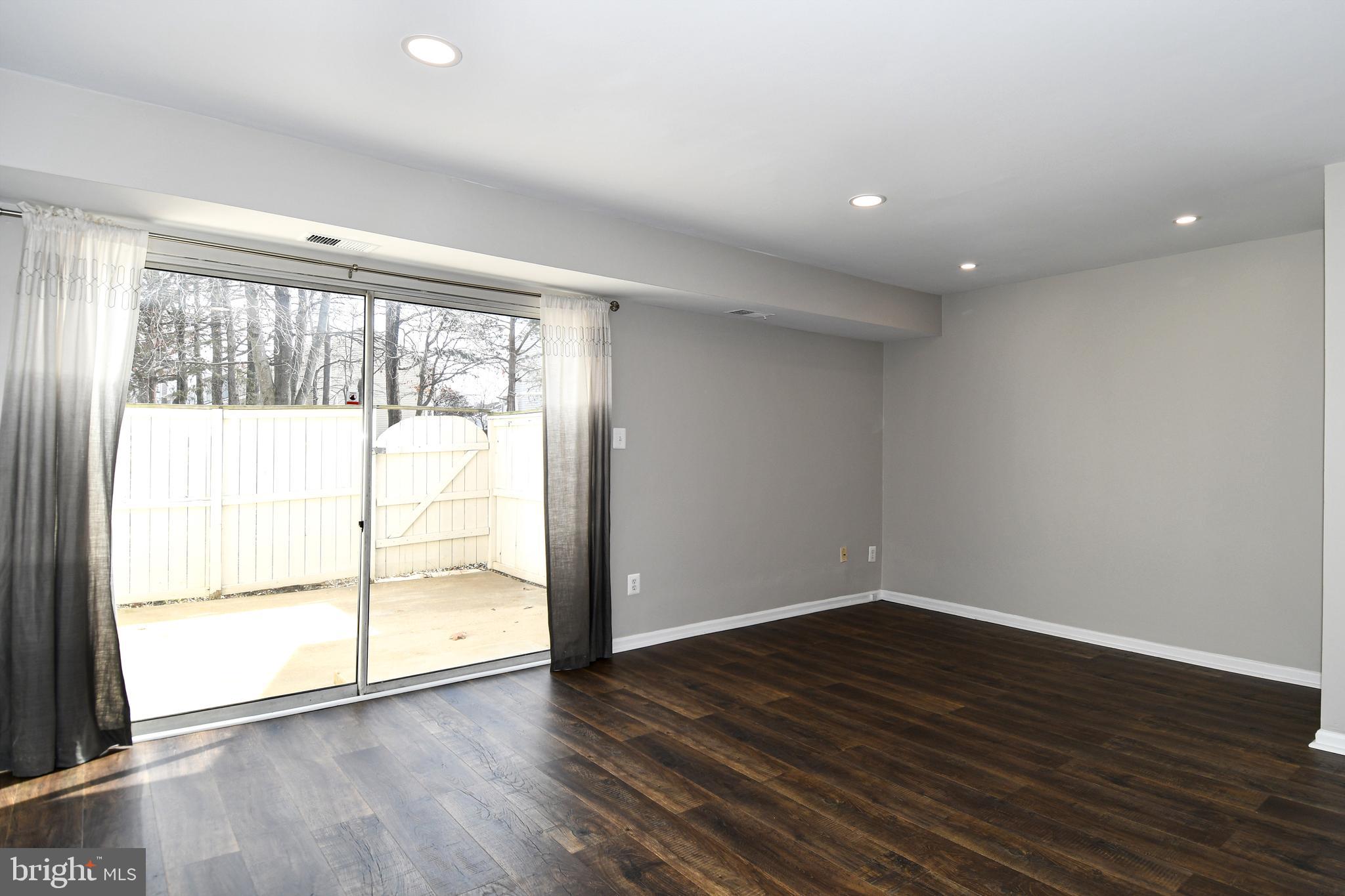53 Essex Square Sterling, VA 20164 - Photo 8 of 25 a view of an empty room with wooden floor and a window