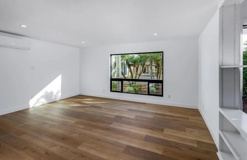 250 Hillcrest Drive Encinitas, CA 92024 - Photo 15 of 54 a view of an empty room with a window and wooden floor