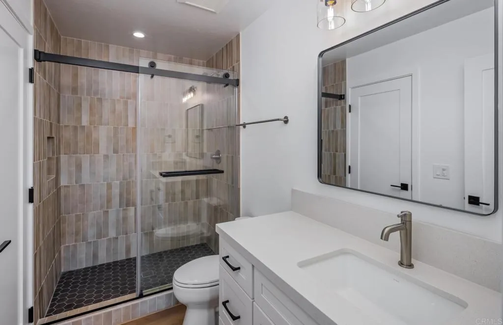 250 Hillcrest Drive Encinitas, CA 92024 - Photo 43 of 54 a bathroom with a shower sink vanity mirror and toilet