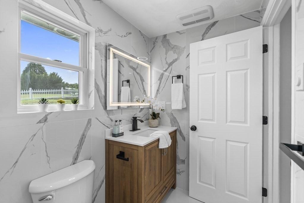 181 Green Street Stoneham, MA 02180 - Photo 19 of 42 a bathroom with a sink a toilet and a mirror