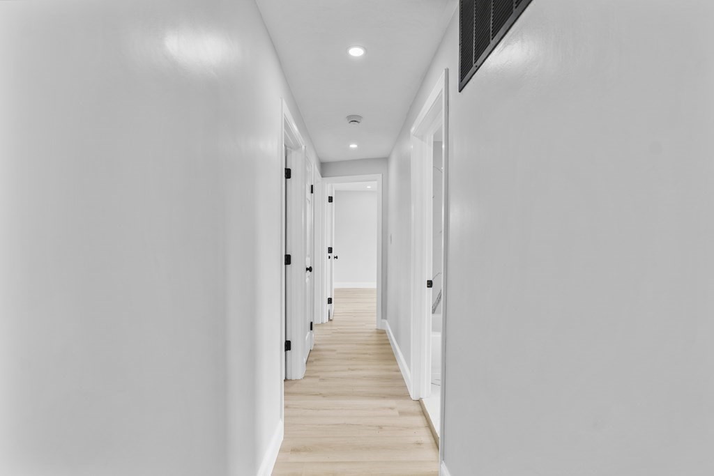 181 Green Street Stoneham, MA 02180 - Photo 21 of 42 a view of a hallway with wooden floor and staircase