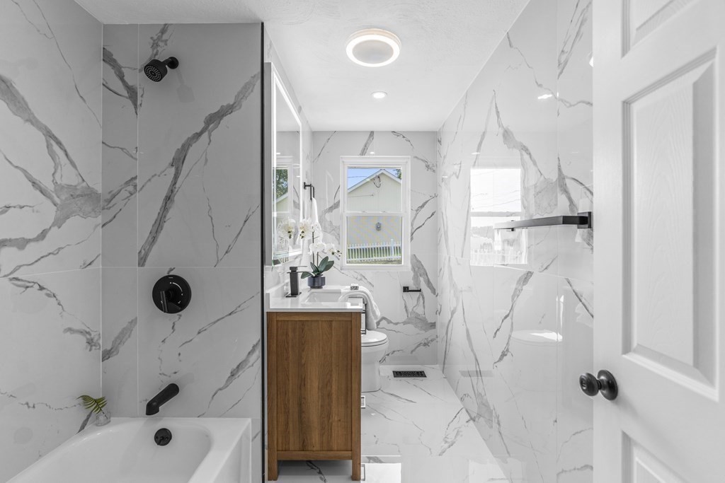 181 Green Street Stoneham, MA 02180 - Photo 23 of 42 a bathroom with a tub sink a mirror and shower