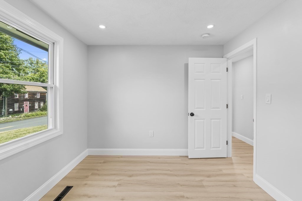 181 Green Street Stoneham, MA 02180 - Photo 30 of 42 a view of an empty room with wooden floor and a window