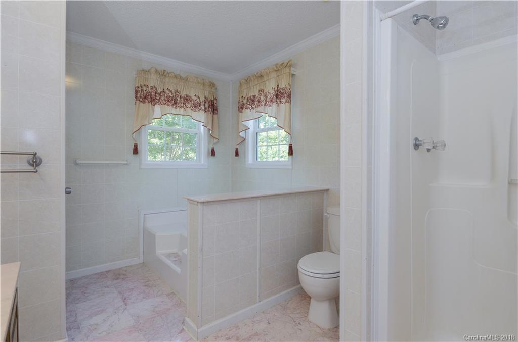 452 Souther Road Fletcher, NC 28732 - Photo 16 of 24 a bathroom with a toilet a sink and a window