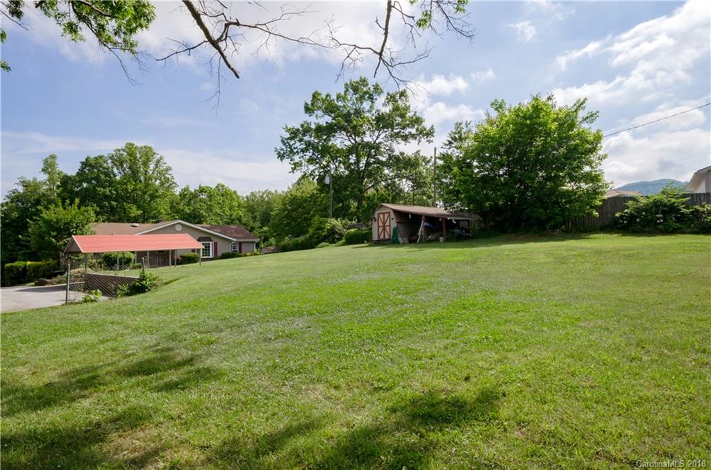 452 Souther Road Fletcher, NC 28732 - Photo 24 of 24 a backyard of a house with table and chairs under an umbrella