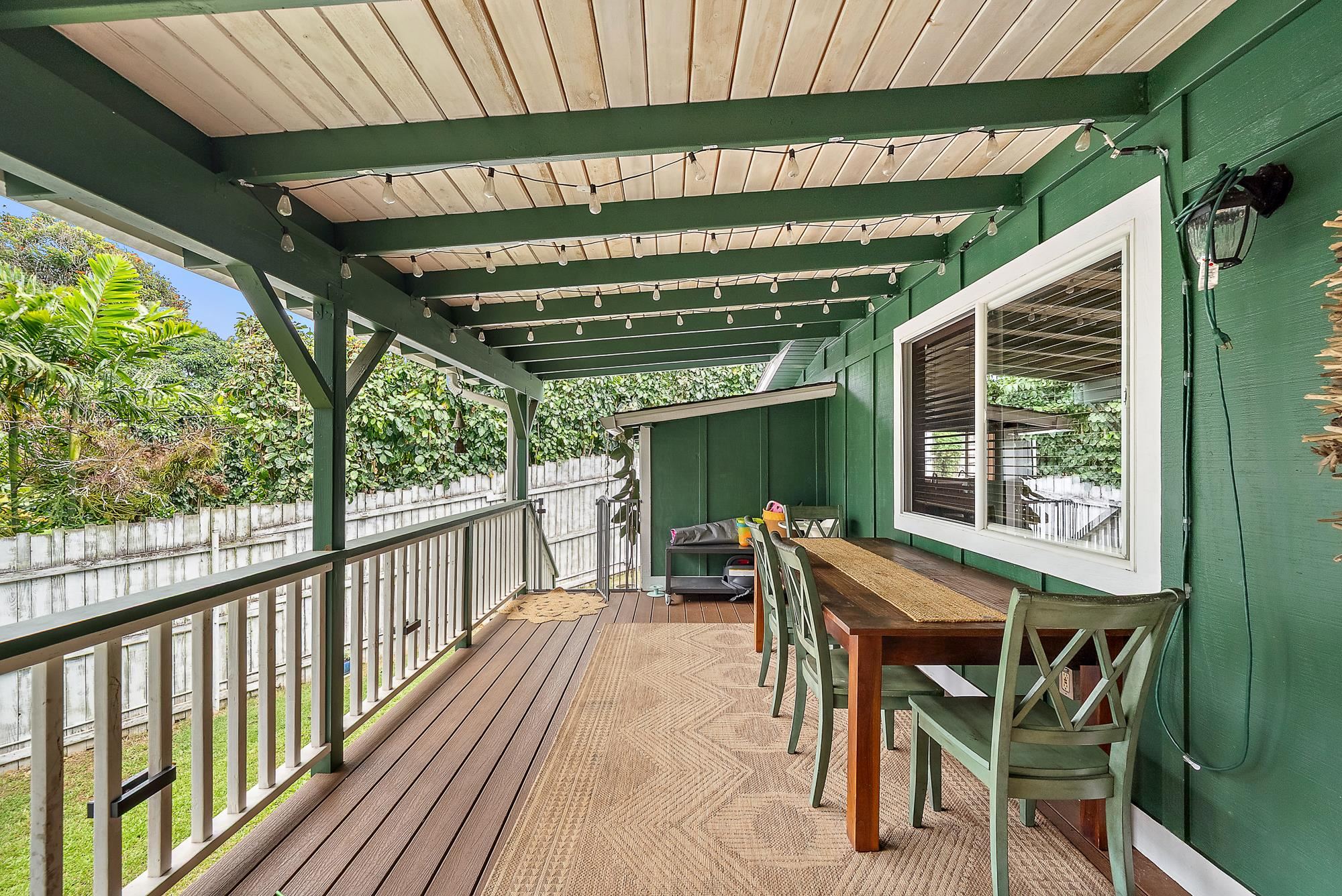 323 West Kuiaha Road Haiku, HI 96708 - Photo 16 of 30 a view of a patio with table and chairs with wooden floor and fence