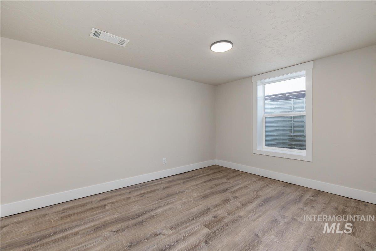 23011 Allendale Road Parma, ID 83660 - Photo 33 of 50 Wood-finish flooring, white trim, recessed lighting, and a white window frame with a window well