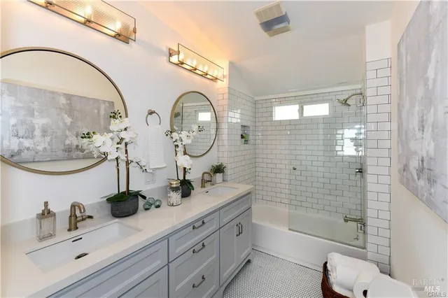 a bathroom with a double vanity sink toilet and shower