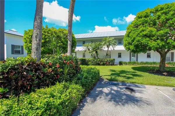 a view of a house with a yard and potted plants
