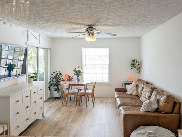 a living room with furniture dining table a chandelier and a window