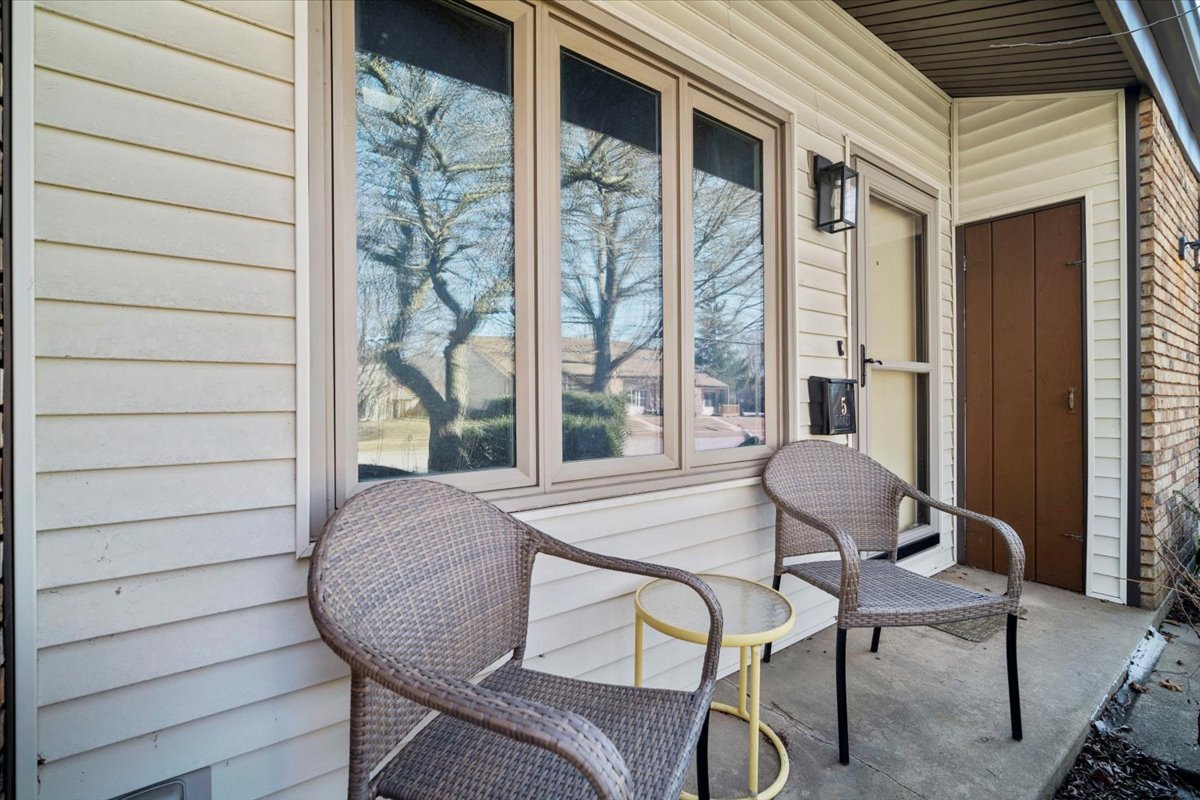1702 Rockingham Drive, Unit 5 Normal, IL 61761 - Photo 2 of 17 a view of a patio with table and chairs and wooden floor
