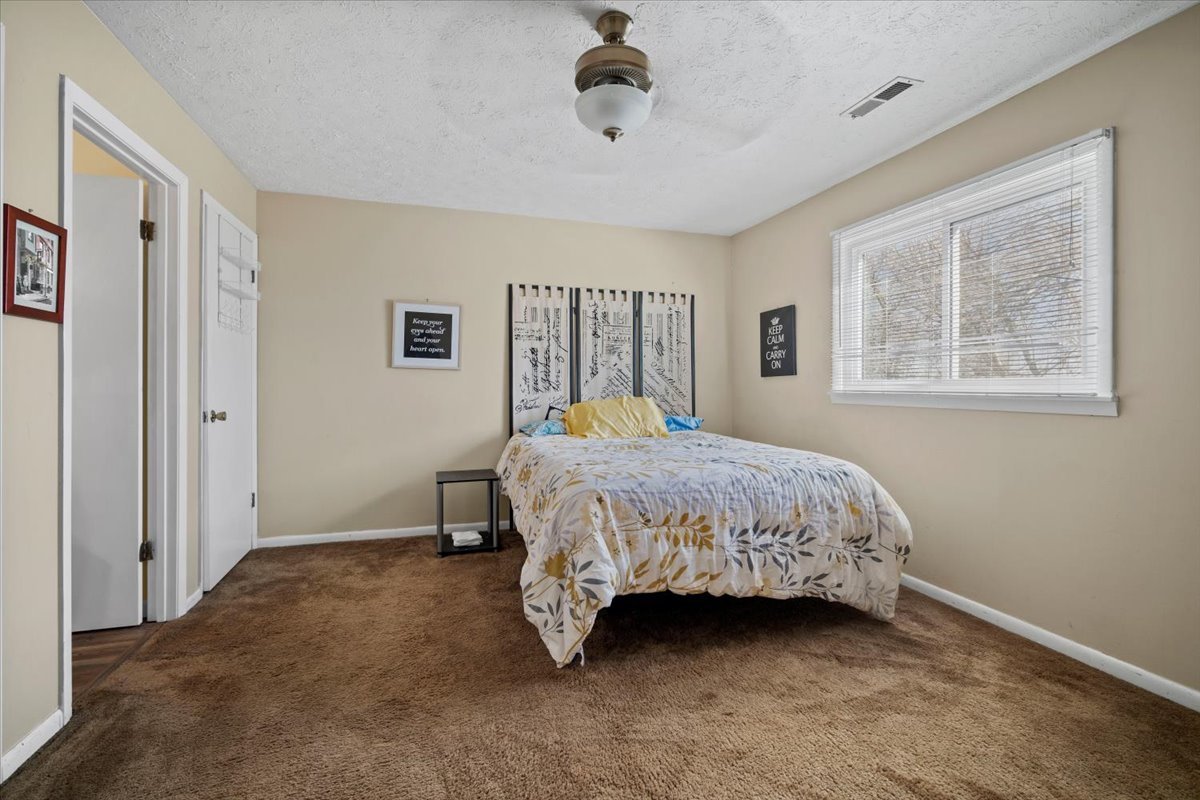 1702 Rockingham Drive, Unit 5 Normal, IL 61761 - Photo 10 of 17 a bed sitting in a spacious bedroom next to a window