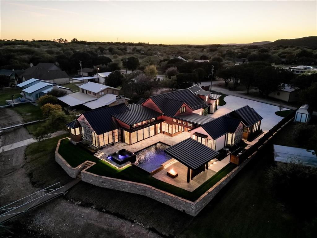 1014 Chaparrel Lane Graford, TX 76449 - Photo 1 of 40 Architecturally distinctive modern home with expansive glass and resort-style outdoor living enhanced by dramatic evening lighting.