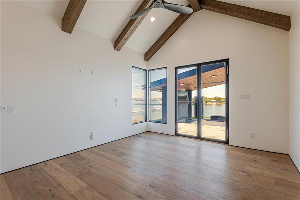 1014 Chaparrel Lane Graford, TX 76449 - Photo 21 of 40 This elevated suite sits in a quiet, private corner of the home, sharing its wing with another bedroom and bath. Smart glass windows and patio doors transition effortlessly from open lake views to complete privacy at the touch of a button. Step directly out to the resort-style pool and patio, where indoor and outdoor living blend seamlessly—creating a serene lakeside escape ideal for extended family stays or multi-generational living.