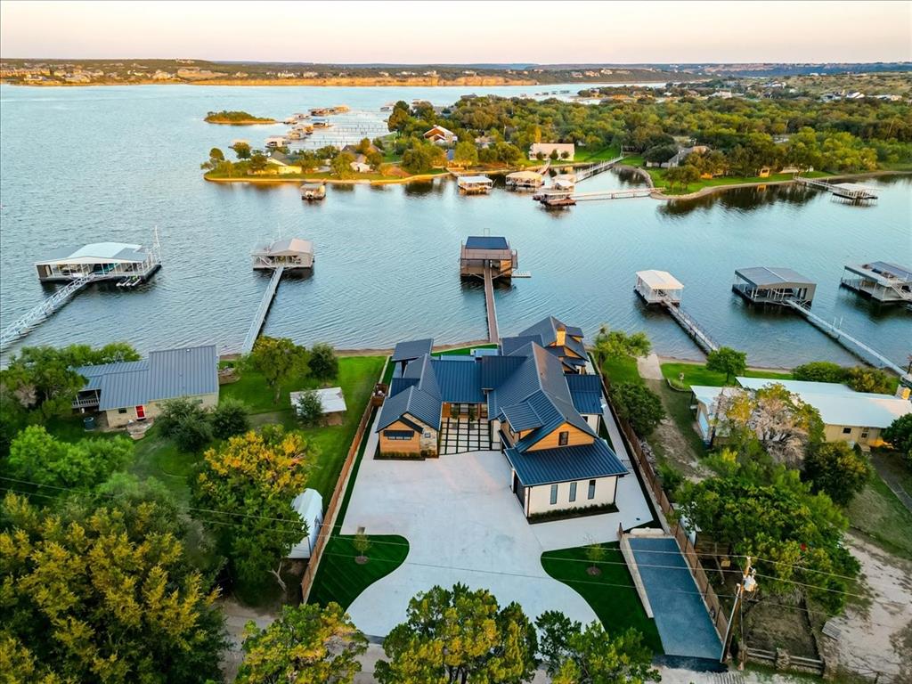 1014 Chaparrel Lane Graford, TX 76449 - Photo 37 of 40 Located in the prestigious gated community of Gaines Bend, this waterfront estate offers prime positioning on the south side of Possum Kingdom Lake. Just minutes from iconic Hells Gate, the dam, and some of the lake’s most popular restaurants and entertainment spots, this property is ideally situated for boating, paddle boarding, and other lake recreation. With excellent water access and sweeping views, this is one of the most desirable areas on PK. Ample on-site parking easily accommodates multiple vehicles, boat trailers, and other water toys—a rare and valuable asset at the lake, where space is often limited. Whether hosting a weekend crowd or managing your own gear, this property is designed to handle it all with ease.