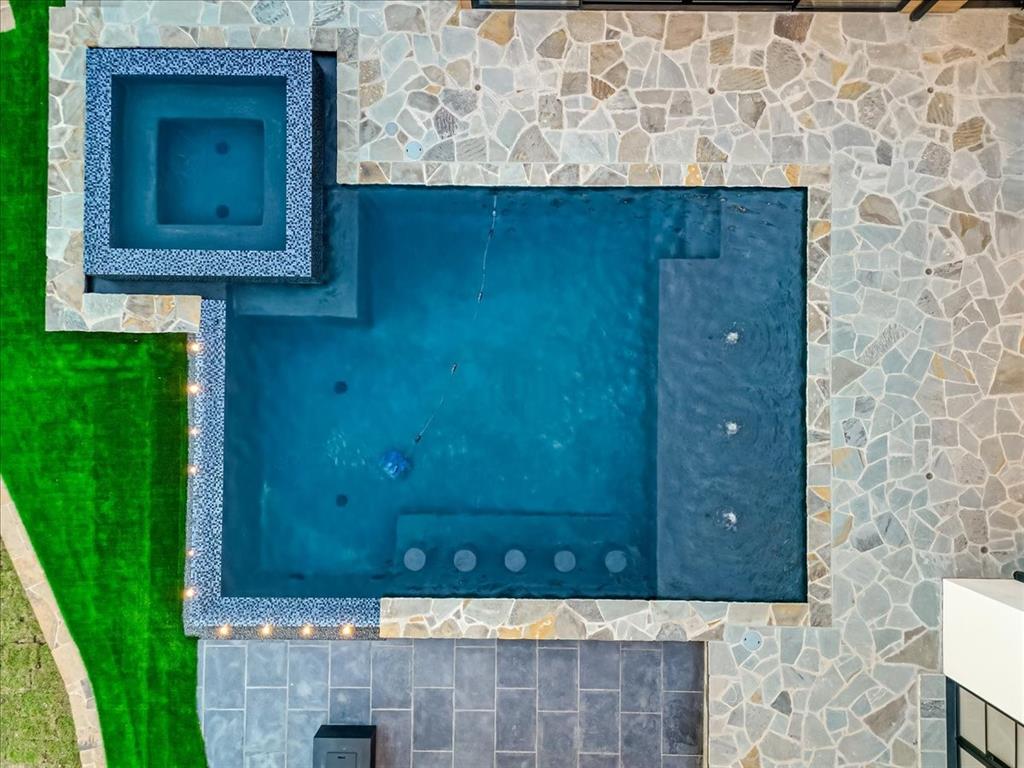 1014 Chaparrel Lane Graford, TX 76449 - Photo 38 of 40 Built for laid-back luxury, this pool is all about versatility—swim, soak, sip, or sun. Enjoy the spa, water features, barstools, lights and views . . . all just steps from the lake.