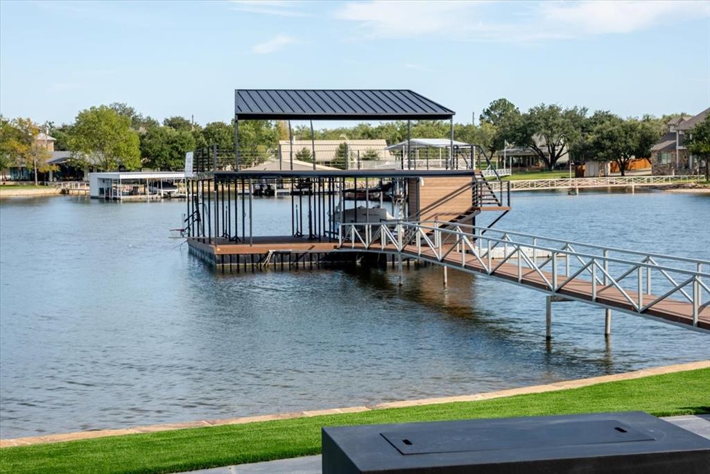 1014 Chaparrel Lane Graford, TX 76449 - Photo 4 of 40 Private 36’ x 40’ Double-Deck Dock - Galvanized steel construction with angled corners for stability, epoxy-coated walkway, composite decking, and approximately 15–17 feet of water depth at full lake level. Outfitted with a 12’ x 26’ party-style platform lift, 11’ x 28’ HydroHoist slip, swing, diving board, basketball hoop, and fishing accessories. Equipped with fresh-water pressure washer, bug lamp, and prewired for a lake pump — this dock is fully loaded for recreation and ready for your boat and toys.
