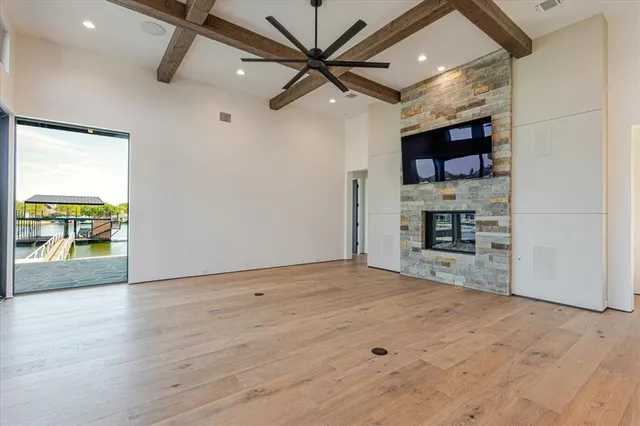 a view of empty room with wooden floor and a ceiling fan