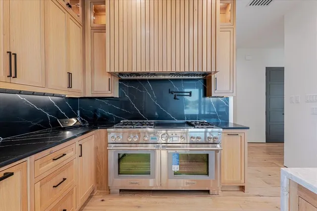 a kitchen with granite countertop cabinets stainless steel appliances and wooden floor