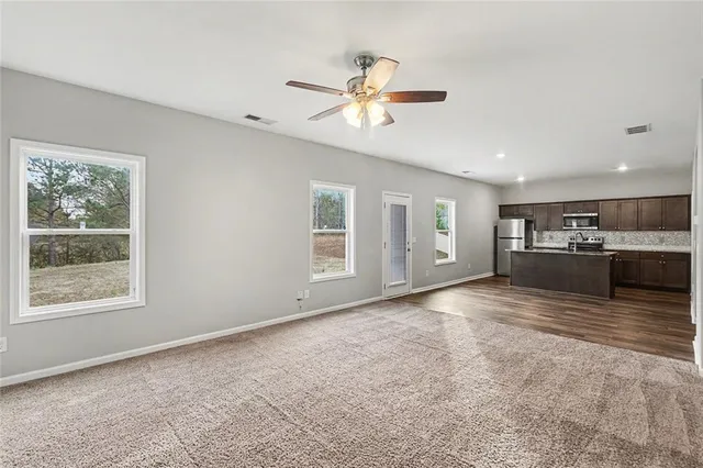a view of an empty room with window and cabinet