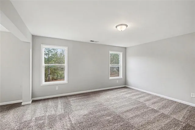 a view of an empty room with window and closet area