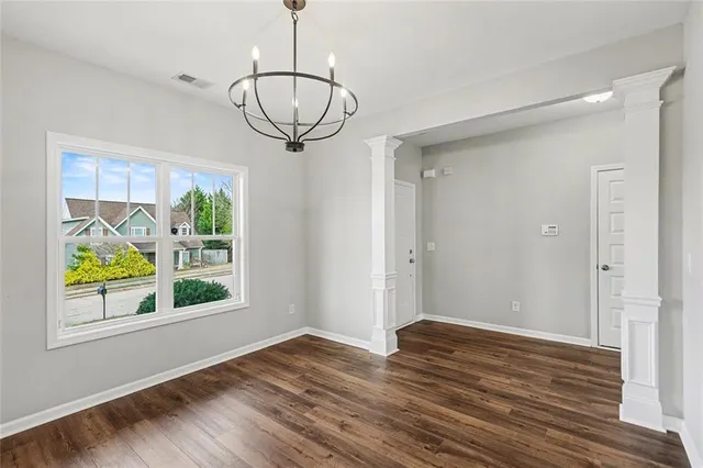 a view of empty room with wooden floor and window