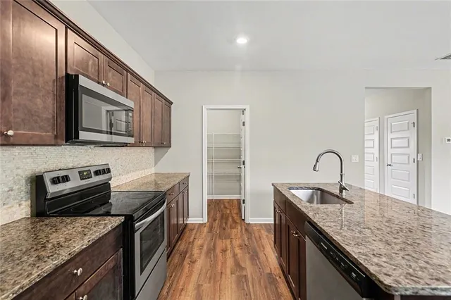 a kitchen with granite countertop stainless steel appliances and wooden cabinets