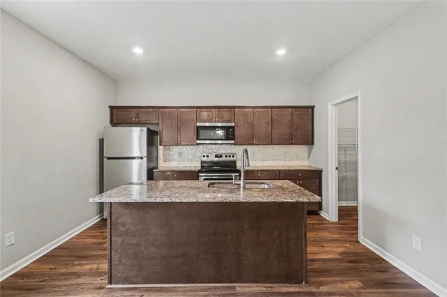 a kitchen with kitchen island granite countertop a sink stove and refrigerator