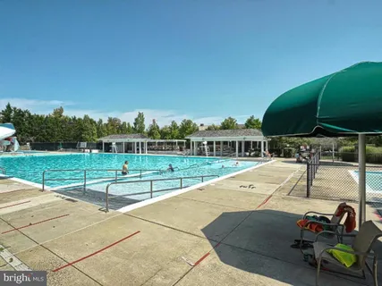 a view of swimming pool with outdoor seating and yard in the back