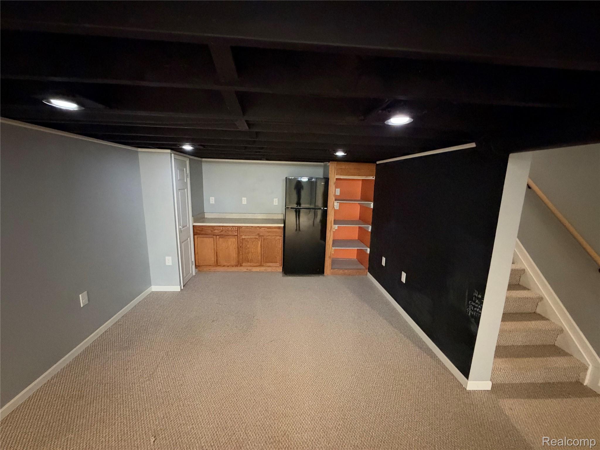 14629 Newburgh Road Livonia, MI 48154 - Photo 23 of 27 Recessed ceiling lighting, light-toned carpeting, built-in wooden cabinetry, integrated shelving, and a finished staircase with wooden railing