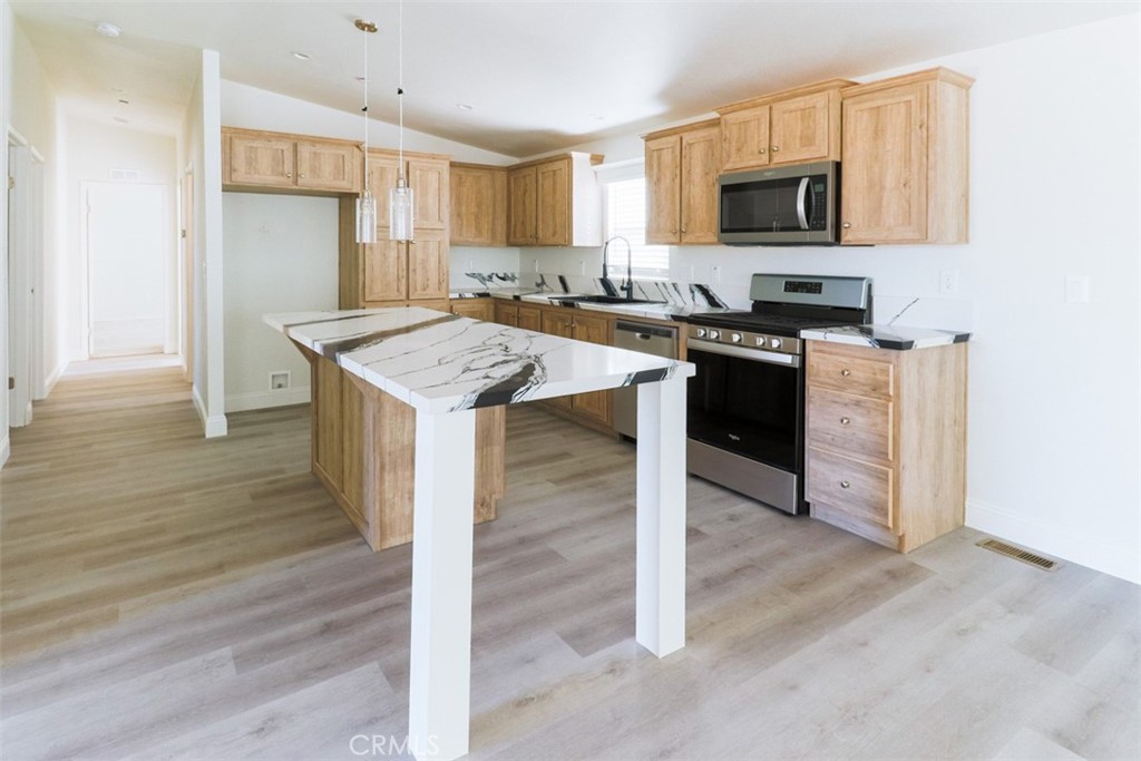40104 Walcott Lane Temecula, CA 92591 - Photo 18 of 41 a kitchen with stainless steel appliances granite countertop a stove top oven a sink a refrigerator white cabinets and wooden floor