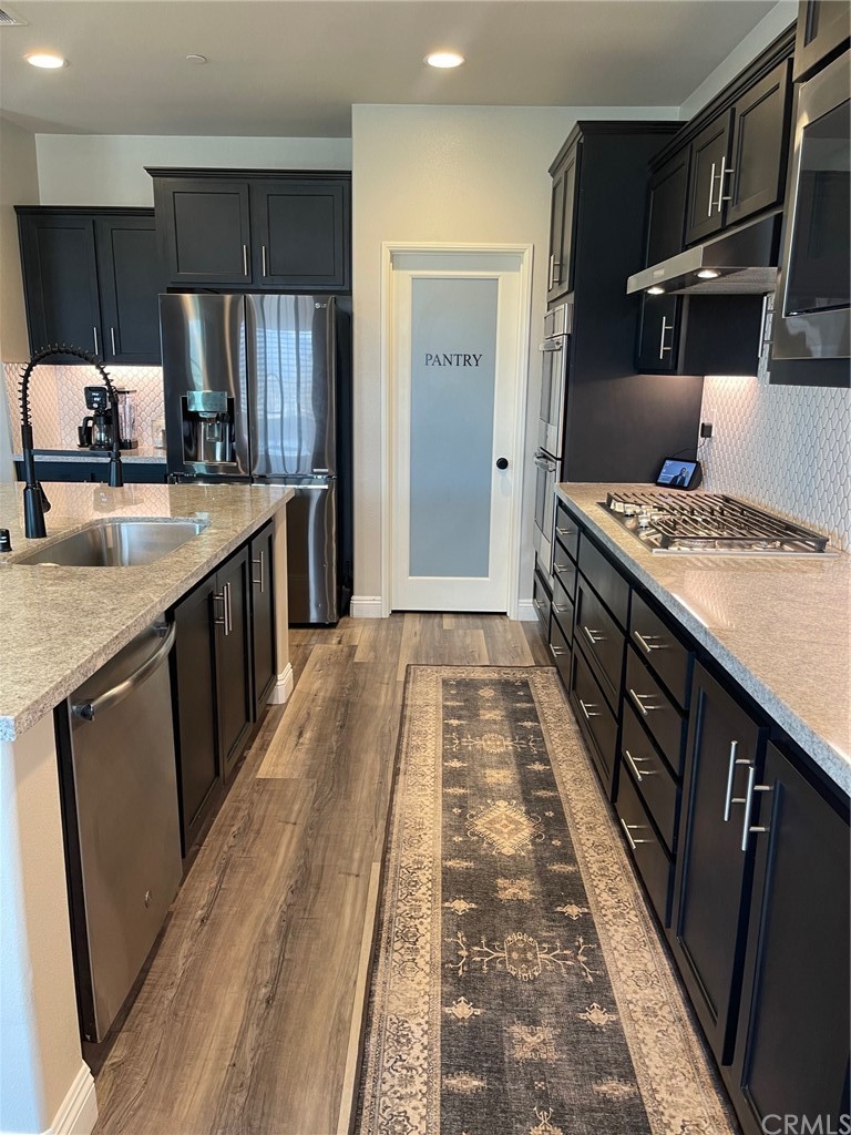35334 Thorpe Trail Beaumont, CA 92223 - Photo 12 of 74 a kitchen with kitchen island granite countertop a sink stove and refrigerator