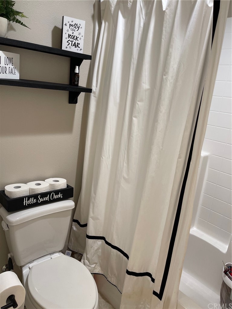 35334 Thorpe Trail Beaumont, CA 92223 - Photo 52 of 74 a white toilet sitting next to a shower curtain