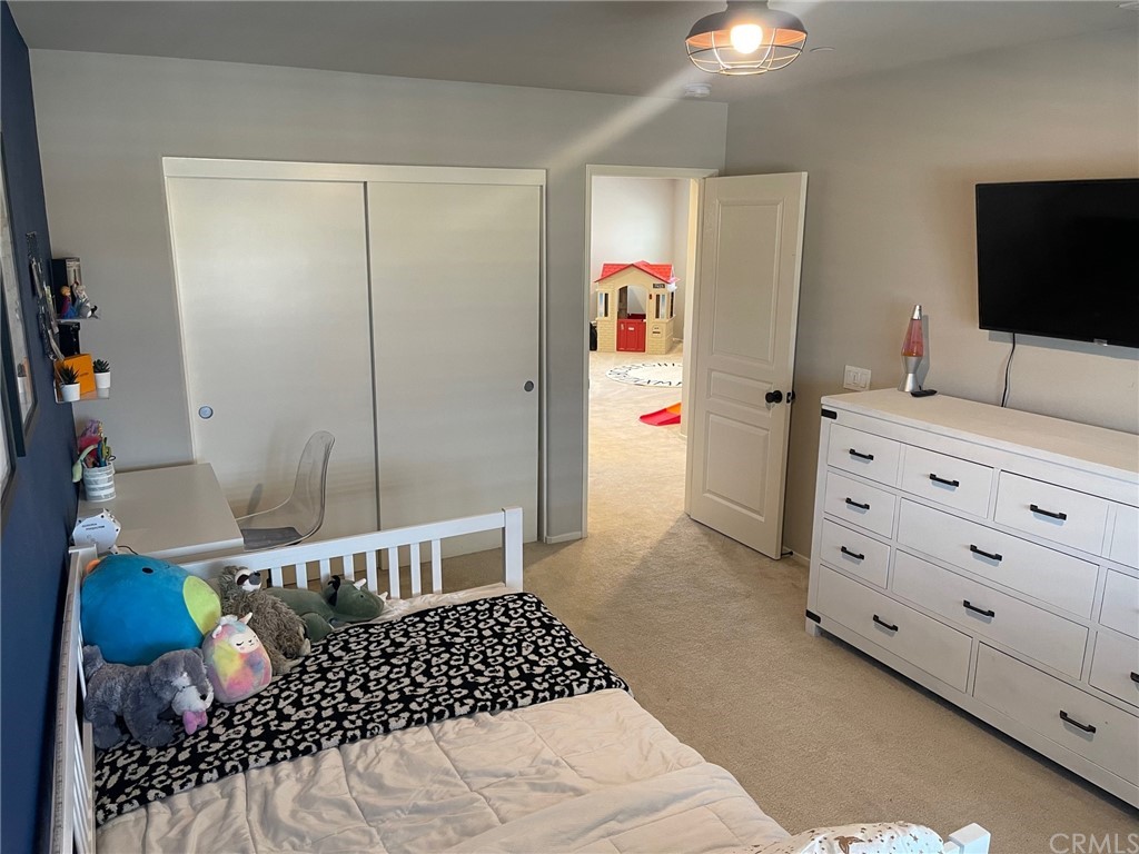 35334 Thorpe Trail Beaumont, CA 92223 - Photo 55 of 74 a bedroom with a bed and a flat tv screen on dresser