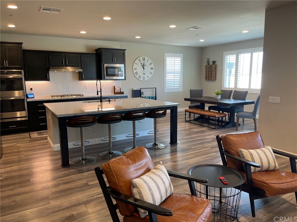 35334 Thorpe Trail Beaumont, CA 92223 - Photo 7 of 74 a kitchen with stainless steel appliances kitchen island granite countertop a dining table chairs refrigerator and sink