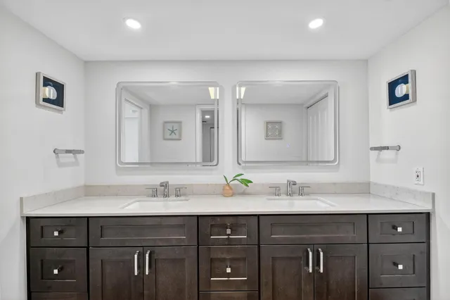 a bathroom with double vanity sinks and a mirror