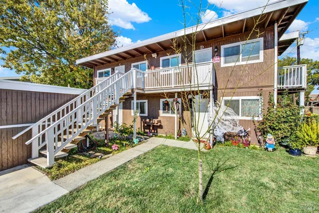 a view of a house with wooden deck and furniture