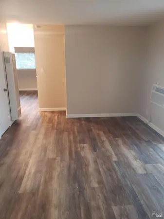 an empty room with wooden floor and door