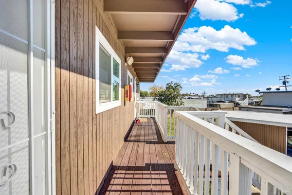 a view of a balcony with wooden floor and fence