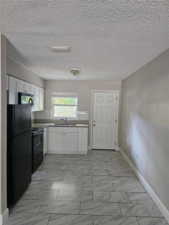 1013 Beecher Street, Unit 1 Leesburg, FL 34748 - Photo 11 of 12 a kitchen with a refrigerator and a sink