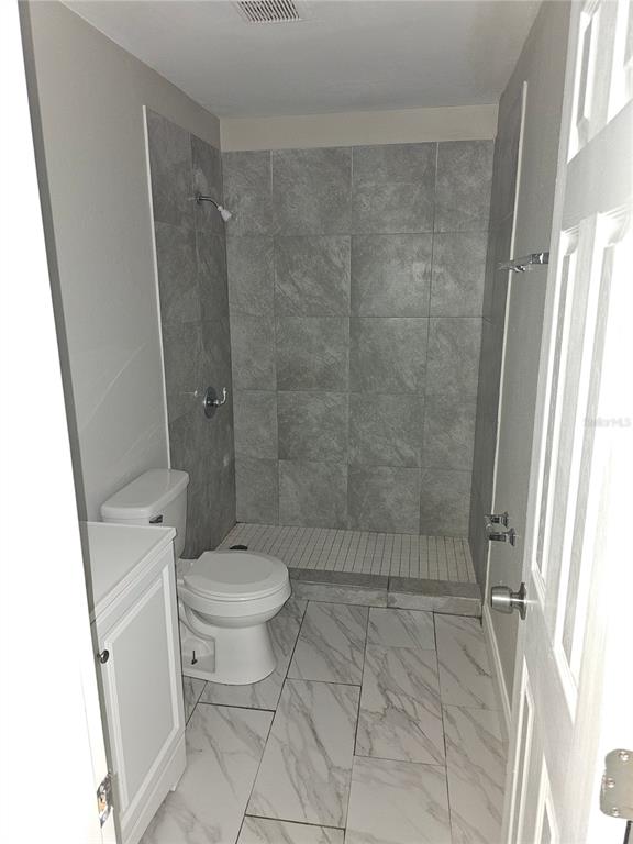 1013 Beecher Street, Unit 1 Leesburg, FL 34748 - Photo 7 of 12 a bathroom with a toilet and a shower