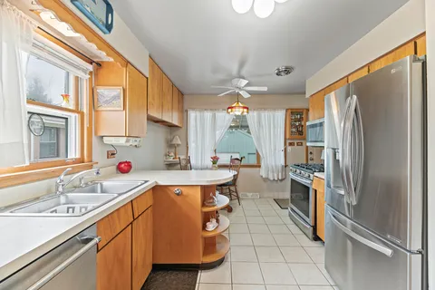 a kitchen with a sink refrigerator and window