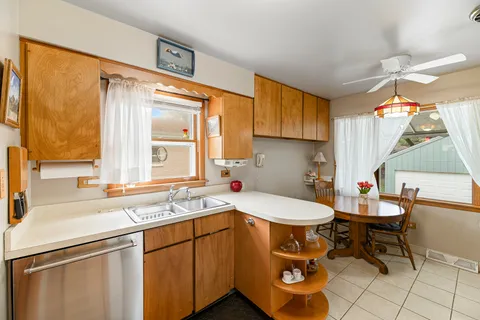 a kitchen with a sink a table and chairs in it