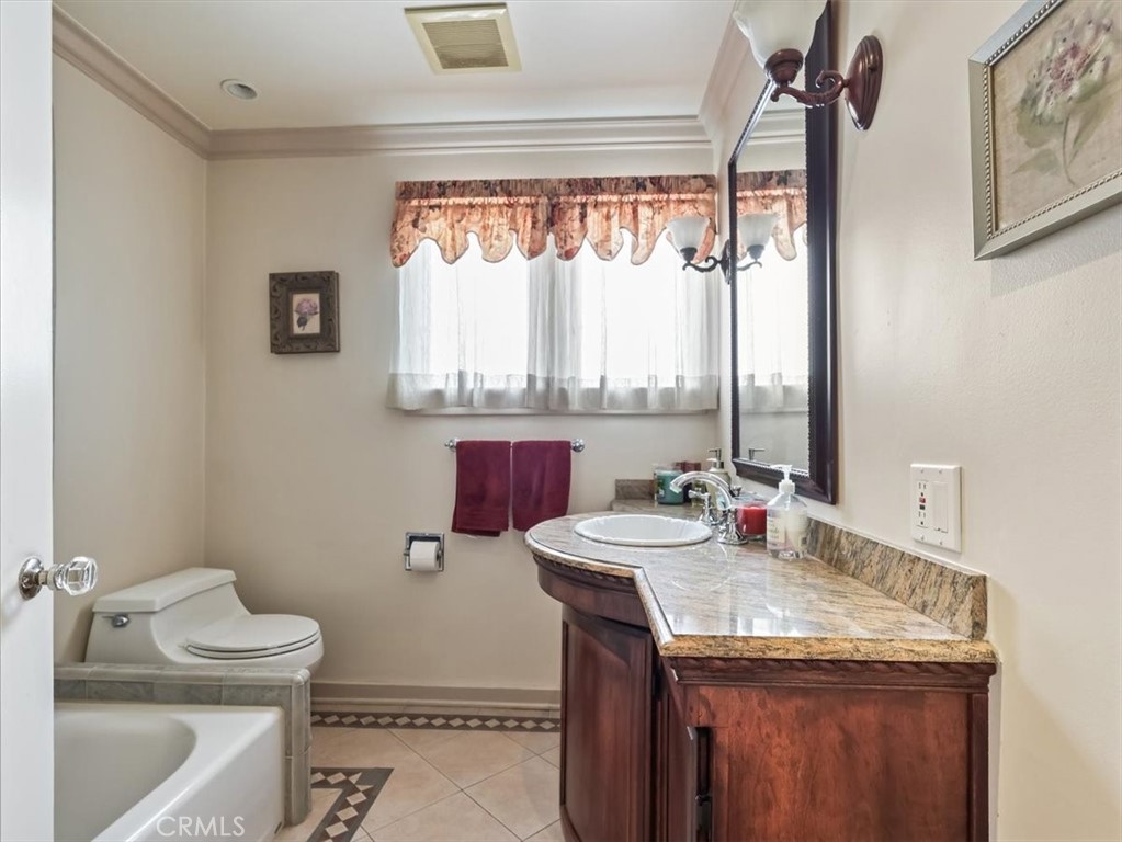 945 Rosemount Road Glendale, CA 91207 - Photo 25 of 31 a bathroom with a granite countertop sink toilet and mirror